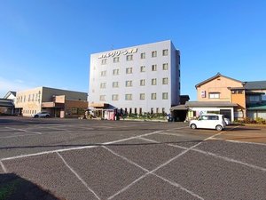 「ホテルグリーン安田」の*駐車場／広々とした駐車場は大型車にも対応！ホテルを正面に、右が別館、左奥が夕食会場の割烹居酒屋です
