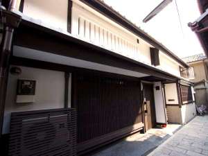 「町家レジデンスイン　城巽あかね庵」の石畳とお稲荷さんが迎えてくれる、京町家の宿。