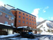 冬のホテル外観。茶色の建物を目印にお越しください！