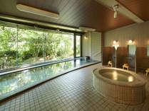 緑に囲まれた大浴場。お肌にやさしい肌触りの天然温水です。
