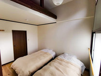 ・【洋室C】シングルベッドが2台設置された吹き抜けがあるお部屋