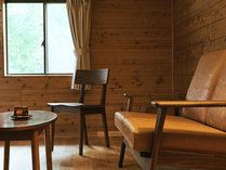 【山小屋のお部屋】備え付けのソファ。窓から見える緑の木々に癒される空間です。
