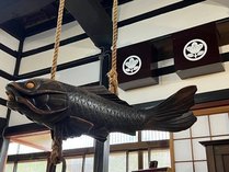 玄関から入ってすぐに目に入る大きな魚の自在鉤