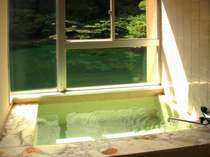 【夢酔庵】の客室眺望風呂。窓からは川の流れを楽しめる。100％天然温泉の為、浴槽に湯の花がある