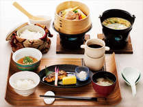 和朝食。季節野菜の蒸籠蒸し、釧路近海で獲れた焼き魚など。白米・玄米・玄米粥から選択できます。