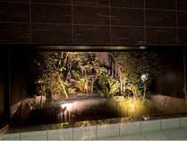 男性用温泉大浴場。ライトアップされた庭園が幻想的に浮かび上がります。
