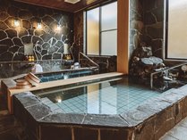 地元文化が生み出した鉄平石で囲まれた昭和を感じる大浴場。