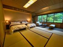 10畳の和室にベッドを備えた和モダンな空間。
