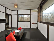 黒の琉球畳と広い窓が特徴の客室（客室例：赤）