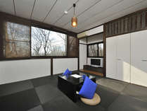 黒の琉球畳と広い窓が特徴の客室（客室例：青）