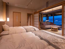 【特別室】最上階８階-展望風呂付和洋室-ベッドルームから萩市街を望む夕暮れ