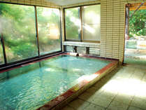 【十和田石風呂】大きな窓が開放的な大浴場には、十和田石を使った湯船がございます