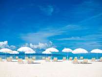 白いパラソル、白い砂浜、エメラルドグリーンの海のコントラストが美しいオクマビーチ。