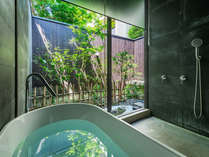大きなガラス張りの窓から坪庭の緑を間近に、露天風呂気分を味わえる浴室。