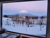 大きな窓から見える日没後の羊蹄山。頂上の白さがひときわ目立ちます