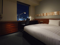 【スタンダードダブル】16.5平米　ベッド幅：140cm　　大きめのライティングデスクが特徴の機能的な室内。