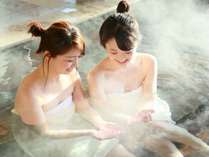 天然温泉の露天風呂でのんびりと旅の疲れを癒す女子旅のお客様