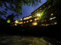 ～夜の外観～鶴仙渓の対岸から。館内の照明が老舗旅館ならではの幻想的な雰囲気。