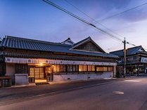 八女福島の伝建地区のほぼ中央に位置する元酒蔵の建物がフロントとレストランを兼ね備えた客室棟へ