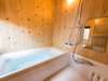 壁には無垢の能登ヒバが張られた浴室。窓からは静かな庭園を眺めながらご入浴頂けます。