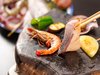 郷土料理「石焼き」。ひおうぎ貝、ひらまさなど刺身でも食べられる新鮮な魚介類や季節の野菜を焼きたてで。